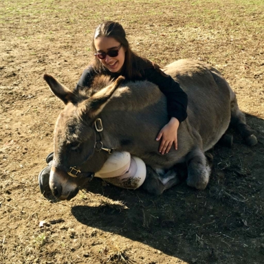 H.O.P.E. equine-facilitated learning instructor snuggling with donkey