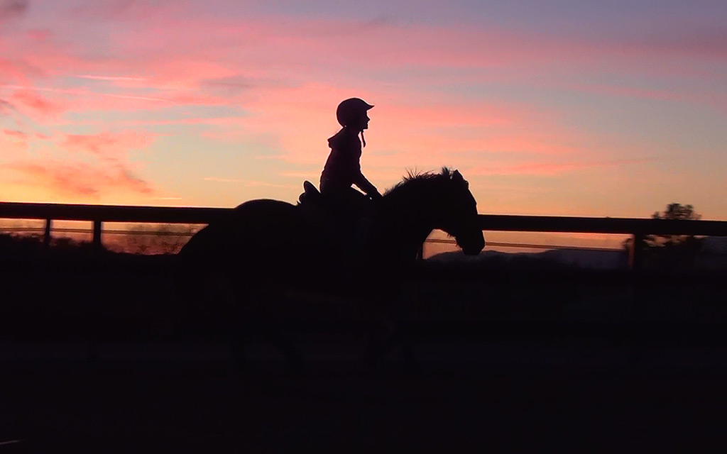 student riding in winter lesson horse with sunset